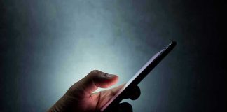 Hand holding a smartphone in the dark