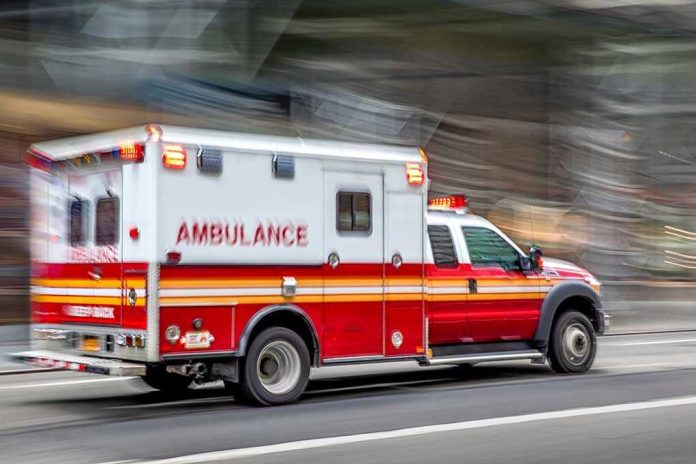 1495131698 Red and white ambulance driving on street