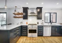 Modern kitchen with black cabinets and stainless appliances.