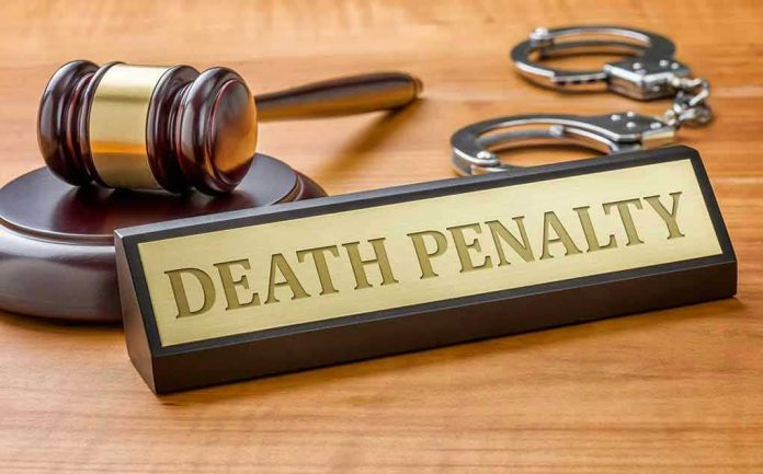 346370309 Gavel, handcuffs, and Death Penalty sign on desk.