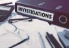 Documents and binder labeled "Investigations" on desk.