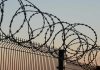 Barbed wire fence against sunset sky background