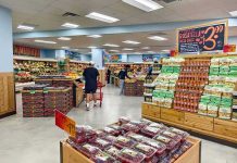 Interior of a grocery store with customers shopping for fresh produce
