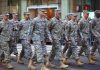Group of soldiers marching in a military parade on a city street