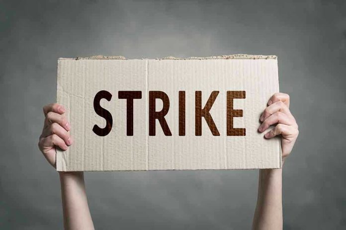 683350906 Two hands holding a cardboard sign saying STRIKE.