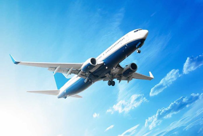 An airplane flying against a clear blue sky with clouds