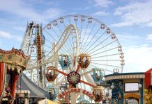 Colorful amusement park scene featuring a ferris wheel and carousel