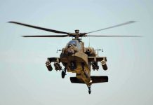 Military Apache helicopter flying in the sky